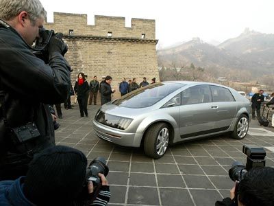 Is drive-by-wire the way of the future for automobiles? Photographers crowd around a General Motors Hy-Wire concept car at the Great Wall of China.