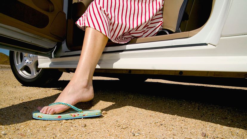 Woman wearing flip-flops stepping out of a car