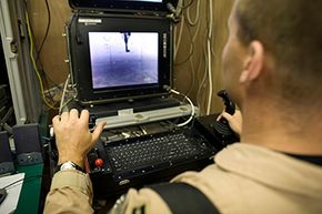 A U.S. Air Force captain controls a Predator drone aircraft from the "cockpit" room at Kandahar Air Field in Afghanistan.”width=