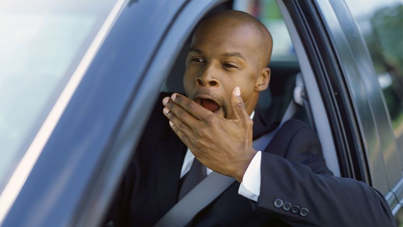 man yawning in car