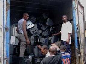 Workers in Lagos, Nigeria, unload imported TVs and PC monitors, most of which will be sent to the local dumps. From there, they will be scavenged for recycling and then burned. ­“border=