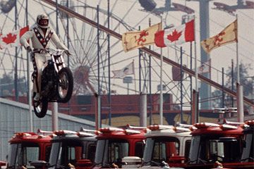 Daredevil motorcyclist Evel Knievel sails over seven Mack trucks during a practice jump in the open-air Canadian national exhibition stadium in Toronto, Ont., on Aug. 20, 1974.