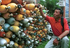 Trash, especially from abandoned equipment like oxygen cylinders, is a huge problem at Mount Everest. Here Appa Sherpa, who ­has climbed Everest 11 times, looks at­ some cylinders collected by the Nepalese government.