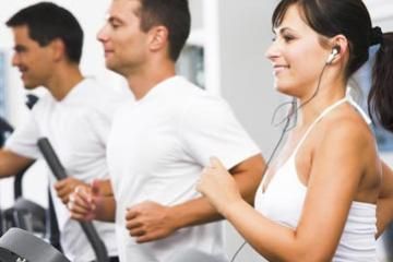 smiling people running on treadmills