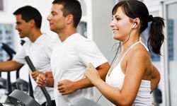 smiling people running on treadmills