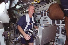 Astronaut Steven A. Hawley, mission specialist, runs on a treadmill on the middeck of the Space Shuttle Columbia. The exercise helped to evaluate the Treadmill Vibration Isolation System (TVIS) for International Space Station (ISS).