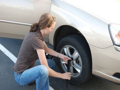 Woman changing flat tire. 