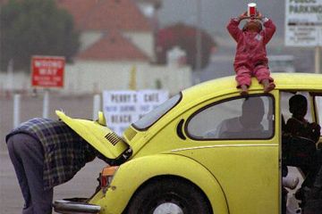 James L. Edward (left) checks the engine of his 1973 Volkswagen in Santa Monica, Calif., to make sure he doesn't have any trouble before making the return trip home to Alabama with his 2-year-old daughter Nahndi Malbrongh (on top of car).