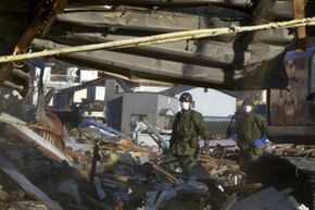 Japanese military search a collapsed building for bodies in March 2011, two weeks after the 9-magnitude earthquake.