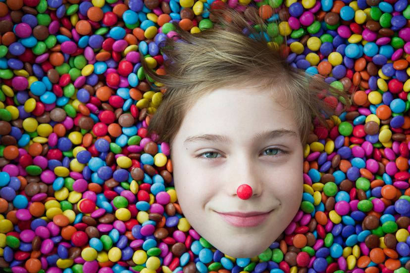 A child in a pile of multicolor candies
