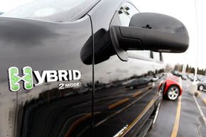 The hybrid logo shines off the front fender of an unsold 2008 Yukon hybrid sports-utility vehicle priced at more than $56,000 on the lot of a GMC Truck dealership in the south Denver suburb of Littleton, Colo., on Feb. 17, 2008.