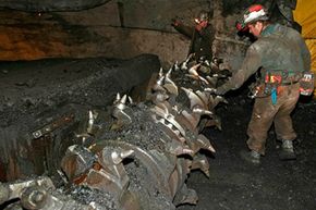 Mine operator Dallen McFarland, right, inspects the teeth of a continuous mining machine at the Horizon Coal Mine outside Helper, Utah.