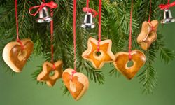 这些姜饼饰品可以直接从树上送到你的嘴里。查看更多节日烘焙食品的图片。＂width=