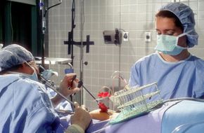 Doctors perform a laparoscopy on a woman in preparation for in vitro fertilization.