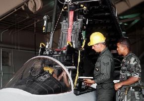 An ejection seat being removed from an F-15C Eagle