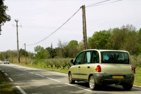 car driving by power lines