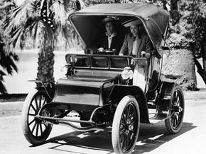 Two women ride in an early model electric car on a street around 1920. Strangely, manufacturers began marketing electric cars to women because of their quietness and supposed ease of use -- which may have helped its first decline in popularity.