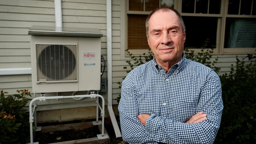 Man poses with heat pump