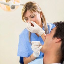 dental hygienist plugging nose, working on patient with bad breath