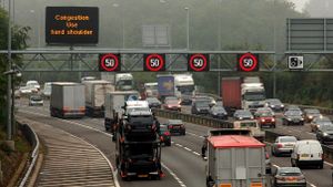 cars on a British highway with sign instructing motorists to use shoulder in congestion