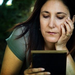 woman looks forlornly at photograph