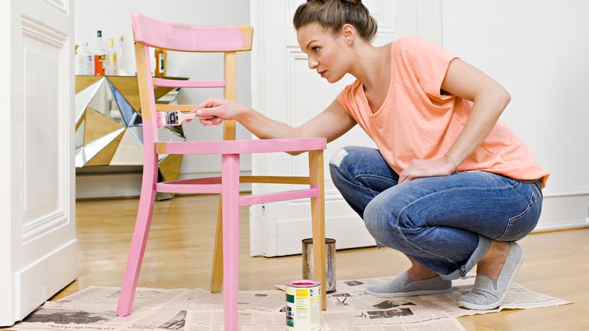 Woman Painting Furniture with Pink Enamel Paint