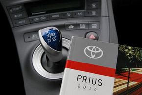 An owner's manual is shown on the console of a 2010 Toyota Prius hybrid car in San Francisco, Calif.