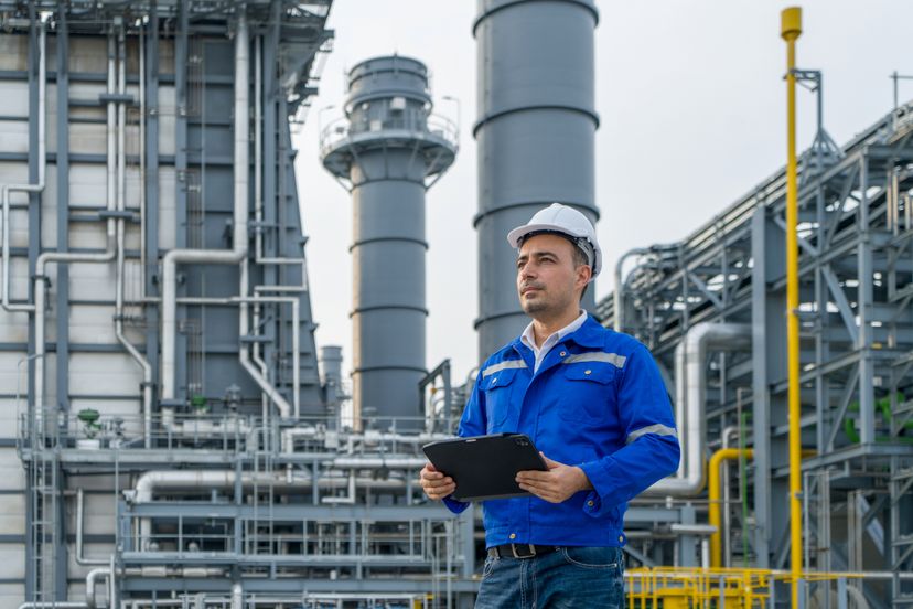 Engineer with digital tablet working at petroleum oil refinery, and power plant.