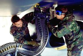 Airmen load ammunition for the F-15's 20-mm cannon.