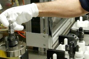 An employee of German maker of electronic car parts Bosch assembling fuel-inje­ction units.