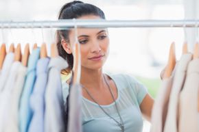 A woman looks through a clothes rack.