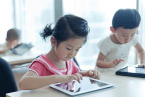 young girl and boy using tablet pcs