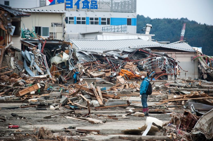 一名男子正在调查2011年日本地震和海啸的毁灭性后果。©Paul Taggart/Corbis＂border=