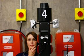 Nurse Lesley Shepherd poses next to a robot tested for use at the Forth Valley hospital in Larbert, Scotland, on June 18, 2010. The robots were deployed in the hospital for tasks such as transporting clinical waste, dirty linen and food.