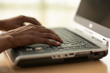 Hands typing on laptop