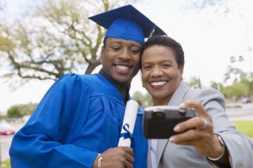 College graduate posing for pictures with mom. 