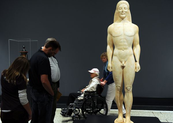 Visitors look at the possibly fake statue at the Getty Villa Museum in Malibu, Calif. on April 18, 2011.