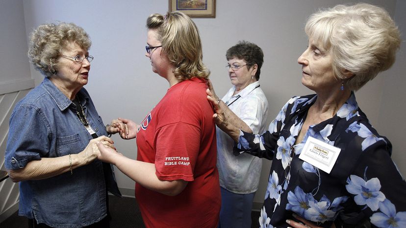 Volunteers lay their hands on a woman to pray for her wisdom, guidance and comfort at the Spokane Healing Rooms Ministries. Jeff T. Green/Getty Images