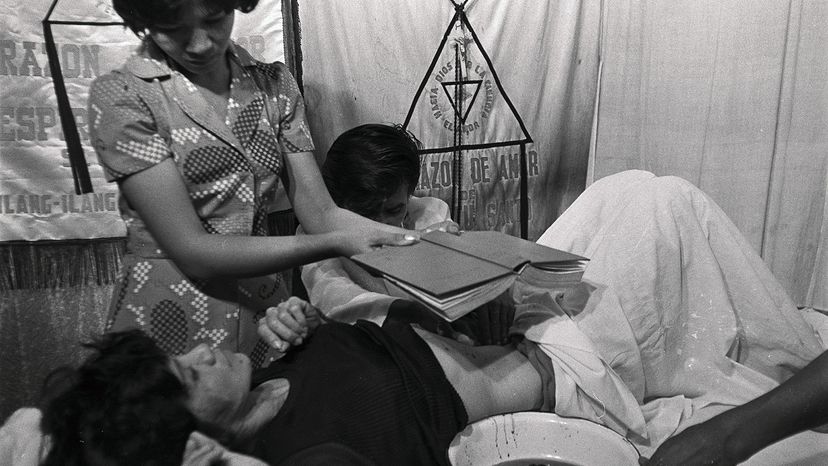 Filipino faith healer Alex Orbito treats a patient using psychic surgery, a pseudoscience that involves using nonhuman animal tissues to fake an operation. Bettmann/Getty Images