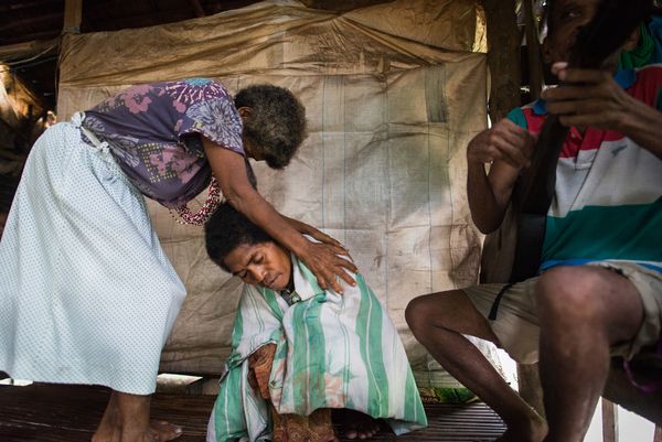 An Aeta healer lays hands on a member of her community.