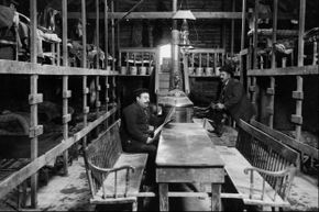 Two workers relax in the immigrant sleeping quarters of the New York State Barge Canal construction project in 1909.