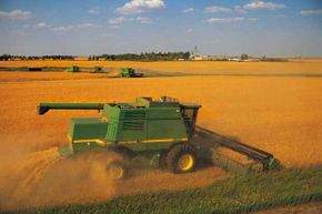 This combine is harvesting wheat on a vast farm in the U.S.A.
