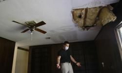 A man wears a mask due to mold growth as he inspects a home in Jupiter, Fla., in April 2008. 