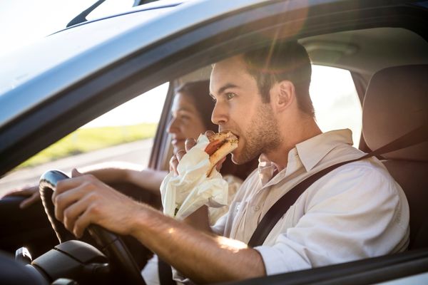 man eating fries while driving