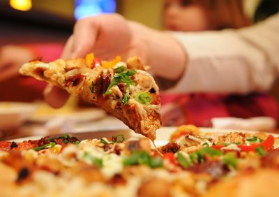 person grabbing a slice of pizza