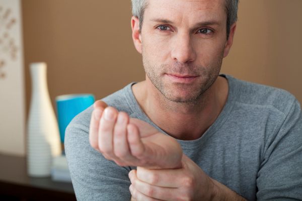 A man rubs his wrist.