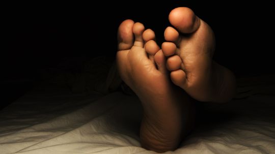 Why do some cultures believe you shouldn’t sleep with your feet toward the door?