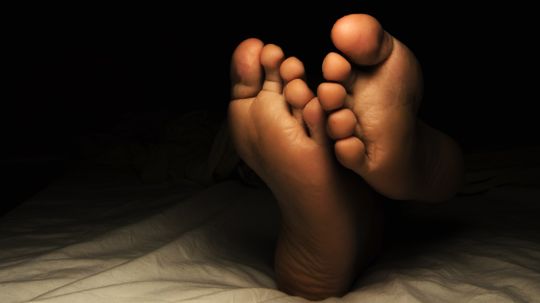 Why do some cultures believe you shouldnâ€™t sleep with your feet toward the door?