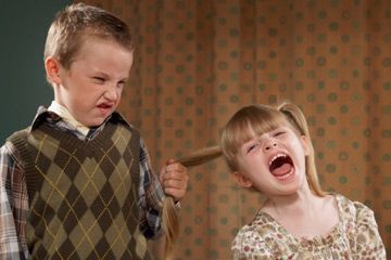 boy pulling girl's pigtail