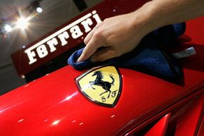 A man cleans a Ferrari logo during a press day at Parc des Expositions Porte de Versailles on Oct. 1, 2010 in Paris, France.